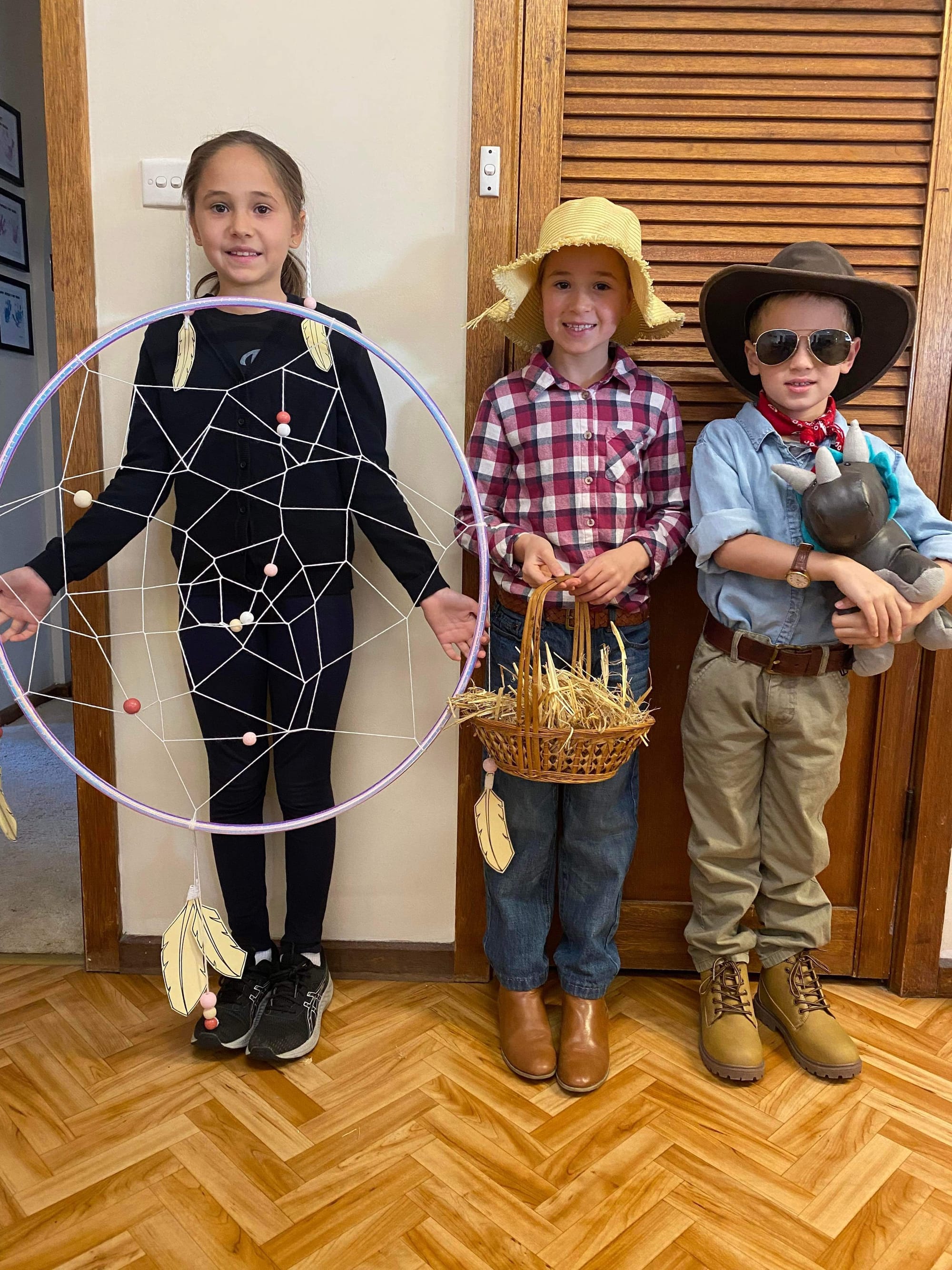 Renmark North School students Georgia, 9, Lucy, 8 and Billy Ekonomopoulos, 6, as a dreamcatcher, farmer and Dr Allan Grant.
